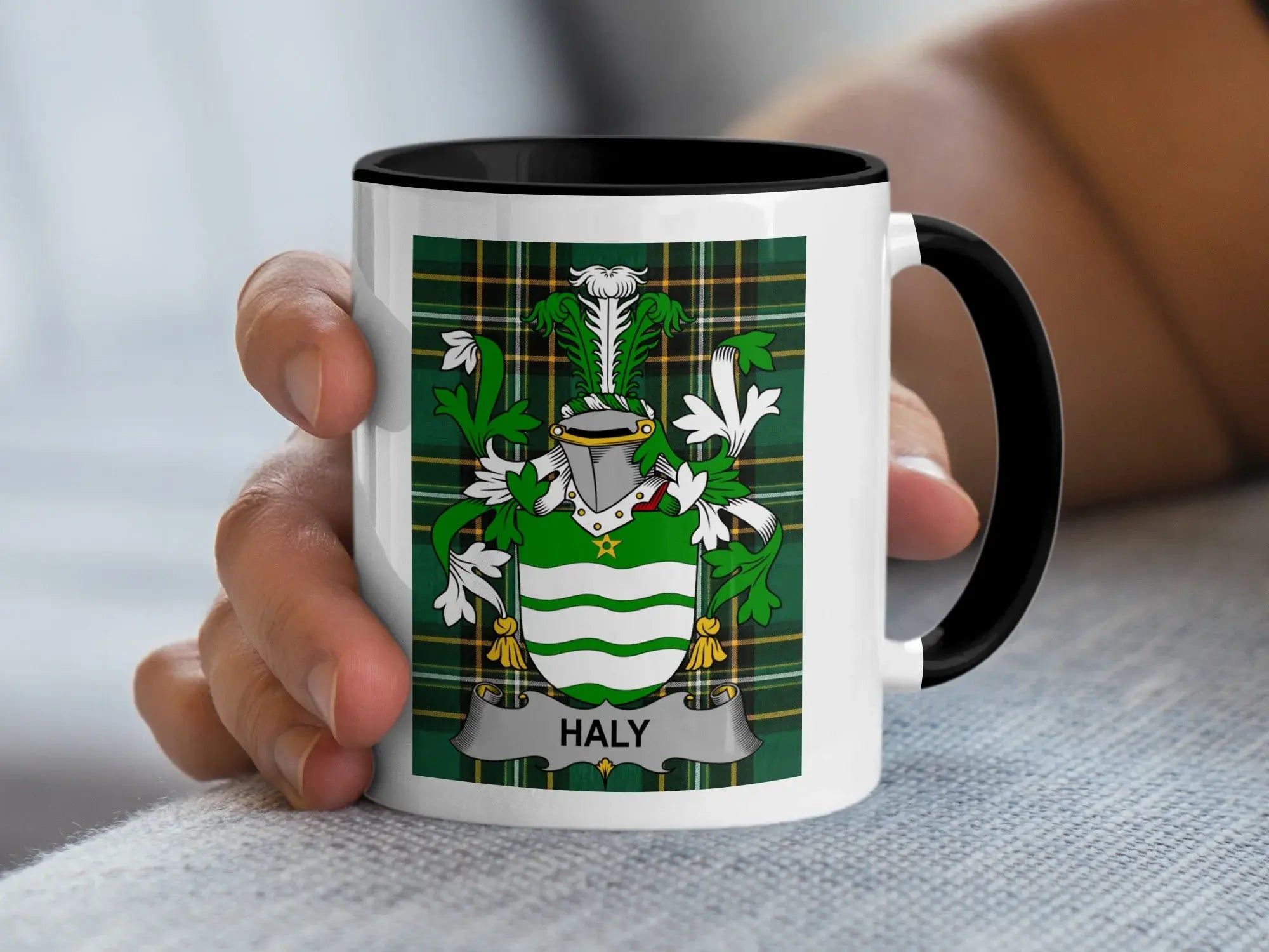 White mug with black rim featuring a green tartan pattern and a coat of arms with "HALY" banner.