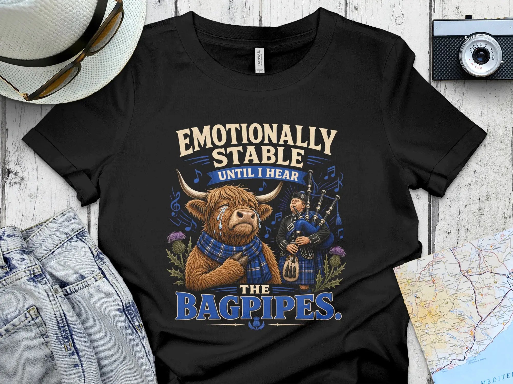 Black t-shirt with a cow playing bagpipes and text "Emotionally stable until I hear the bagpipes".