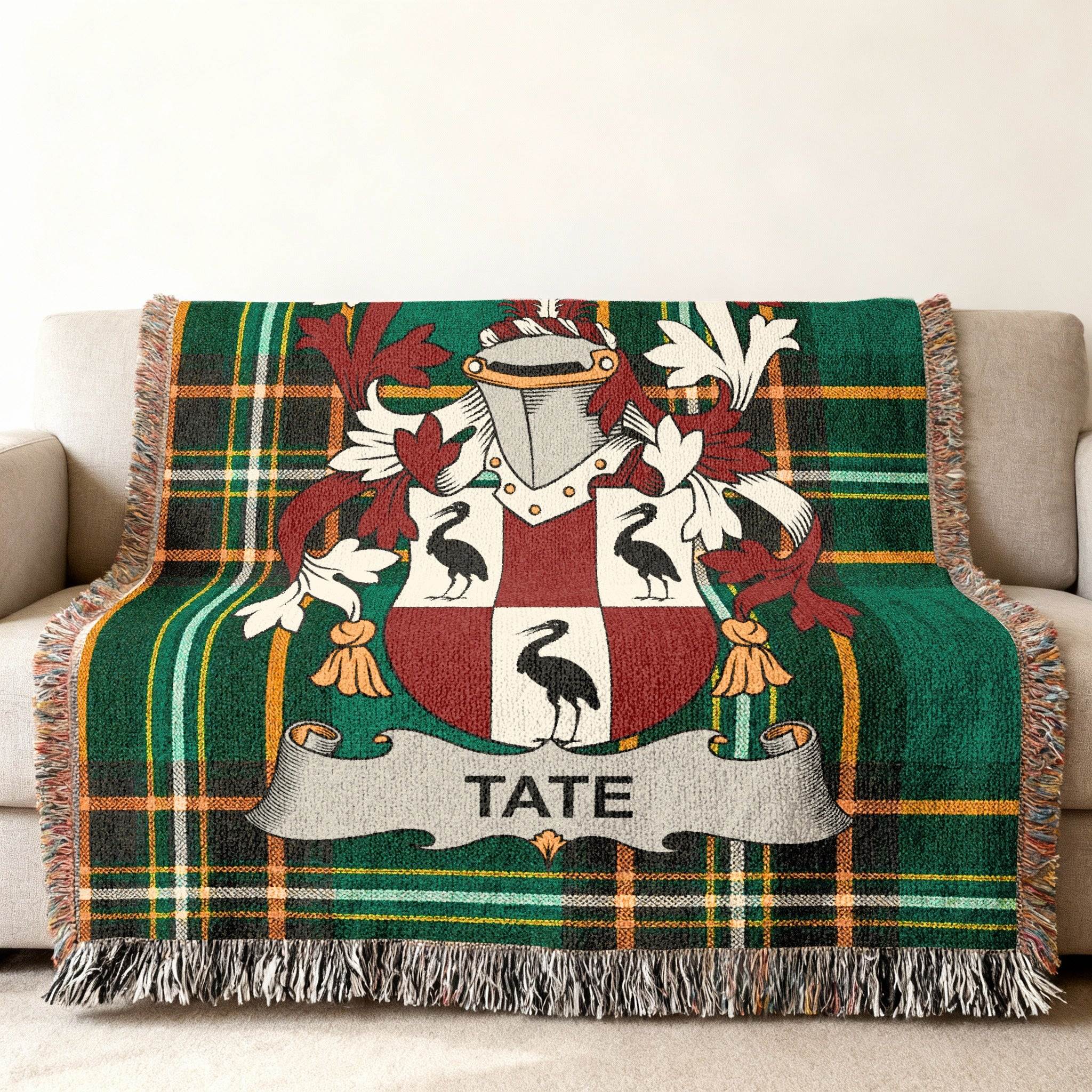 Tate family crest on a green tartan woven throw blanket.