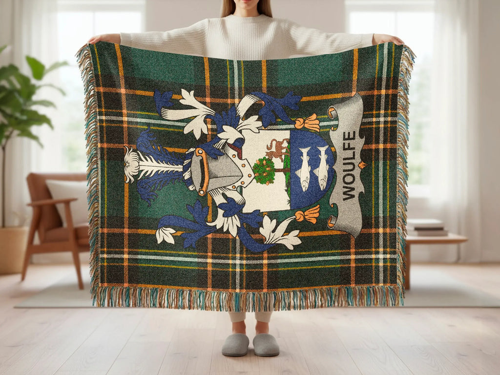 Tartan wool blanket with Clan Wolffe crest, fringed edges, held by a person.