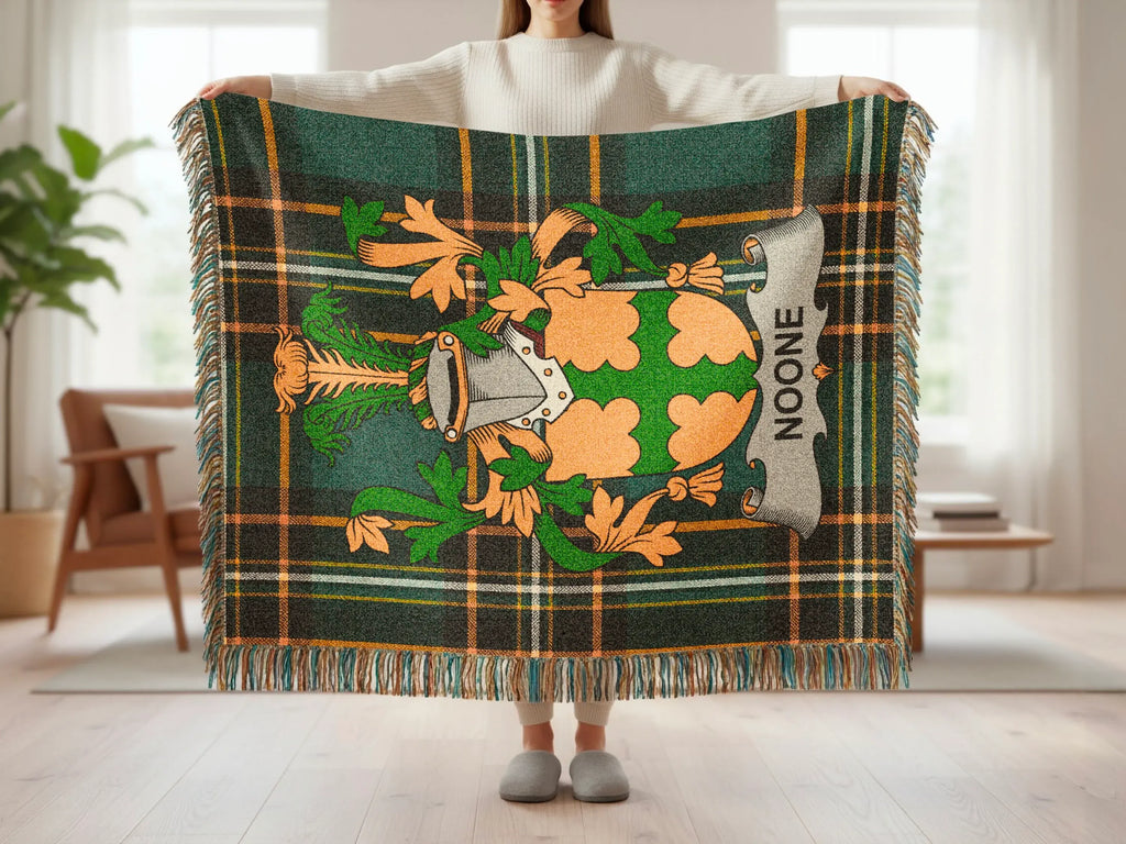 Green tartan blanket with family crest and "NOONE" embroidered on silver shield.
