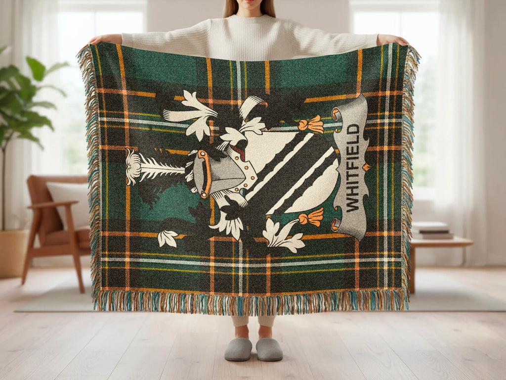Green tartan blanket with Whitfield family crest in center.