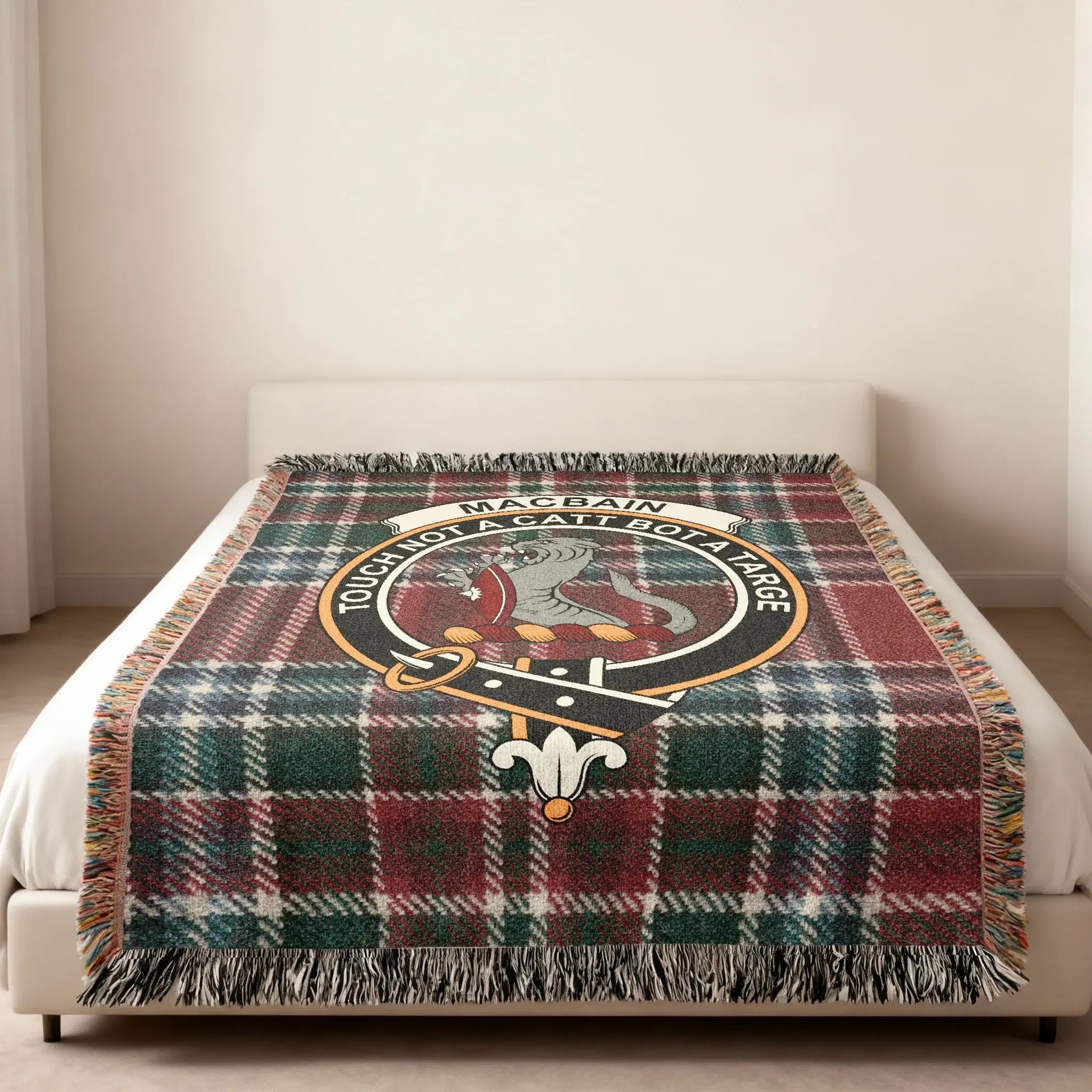 Clan MacBain tartan woven blanket — lifestyle shot showing fringe border and clan crest design
