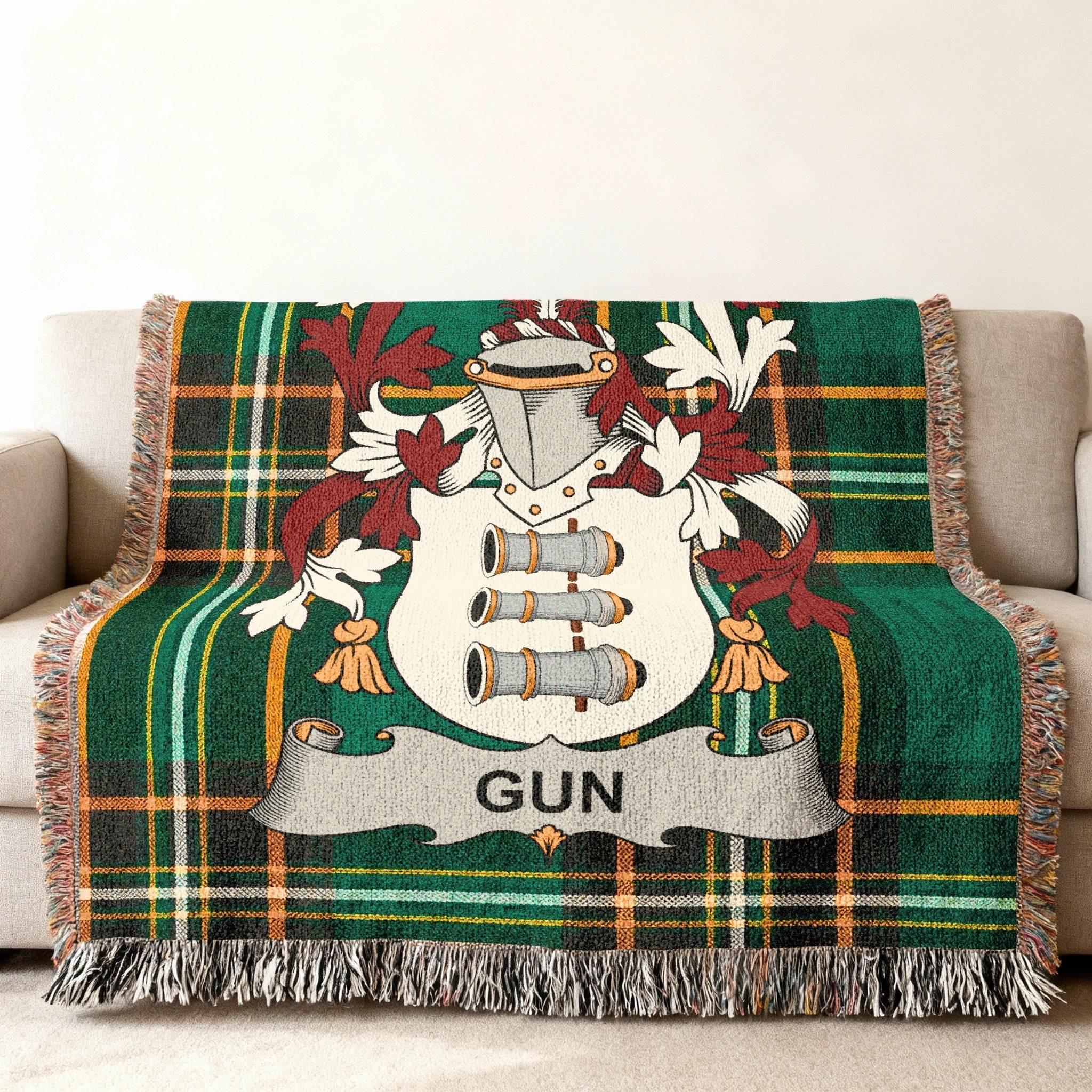 Green plaid blanket with a coat of arms featuring cannons and the name "GUN".