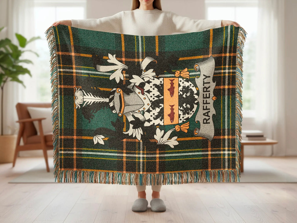 Tartan blanket with Rafferty crest, held by person.