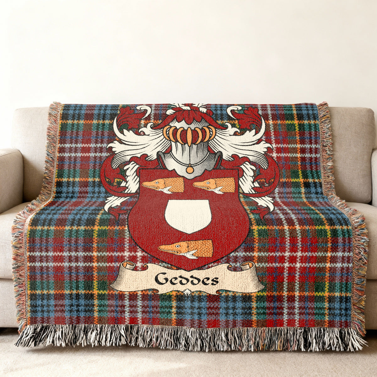 Geddes family crest emblem on a Caledonia tartan woven blanket