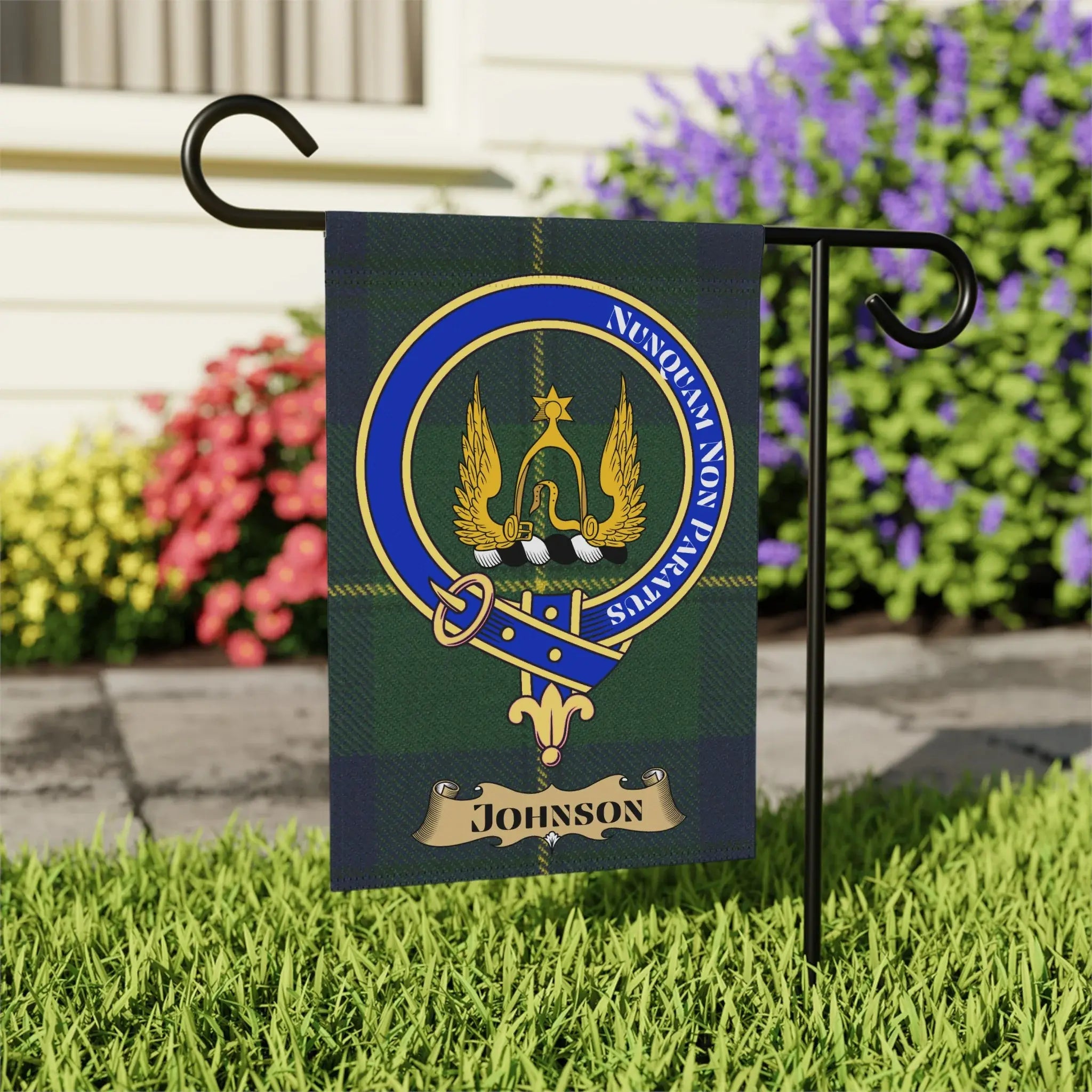 Johnson family tartan flag with crest and motto in a garden.