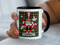 White mug with black rim showing the Candell family crest on tartan background.