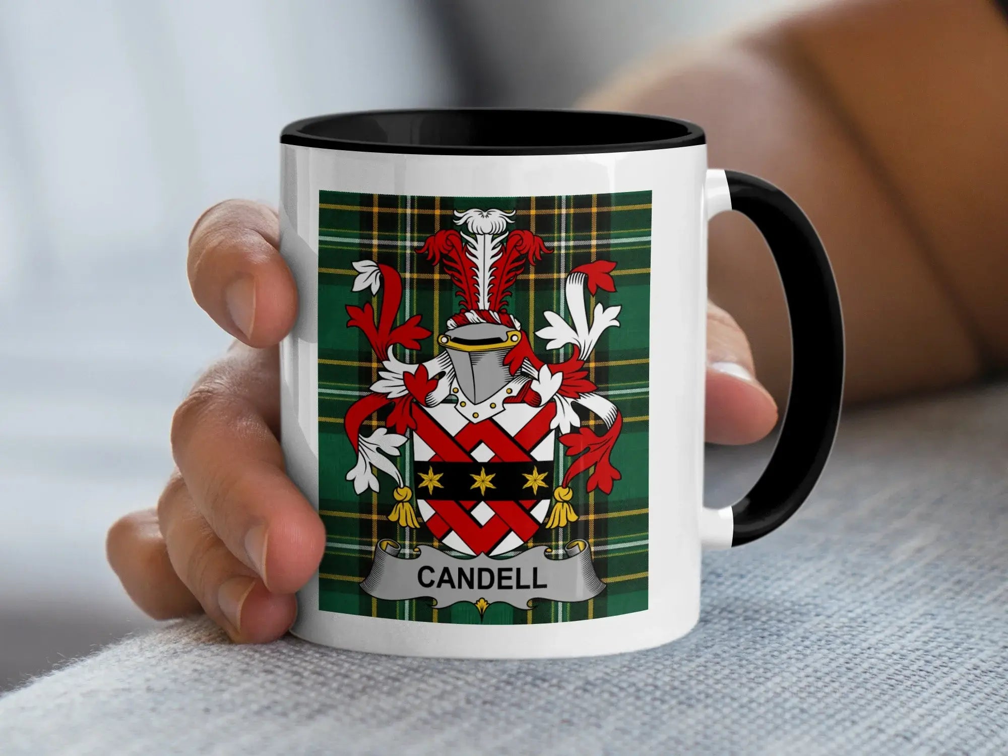 White mug with black rim showing the Candell family crest on tartan background.