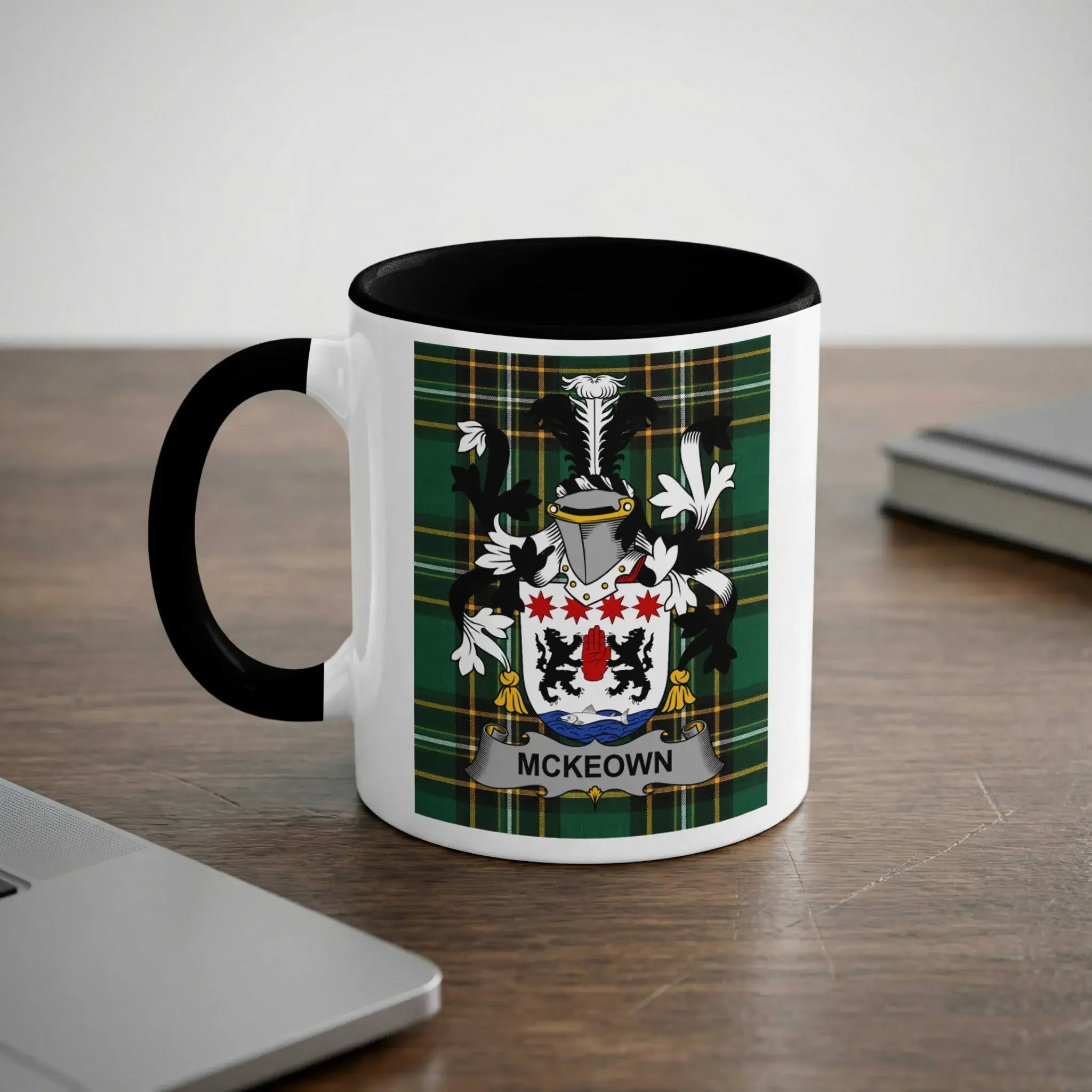 White mug with black rim and handle featuring the McKeown family crest.