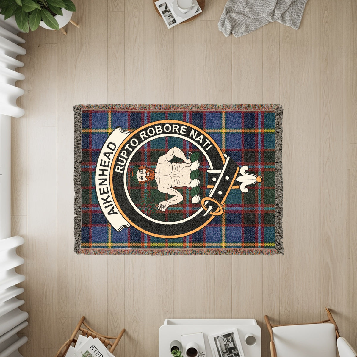 Aikenhead woven blanket displayed on a wall, featuring the crest badge and tartan background