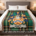 Tartan blanket with a family crest and "Swift" banner draped on a bed.