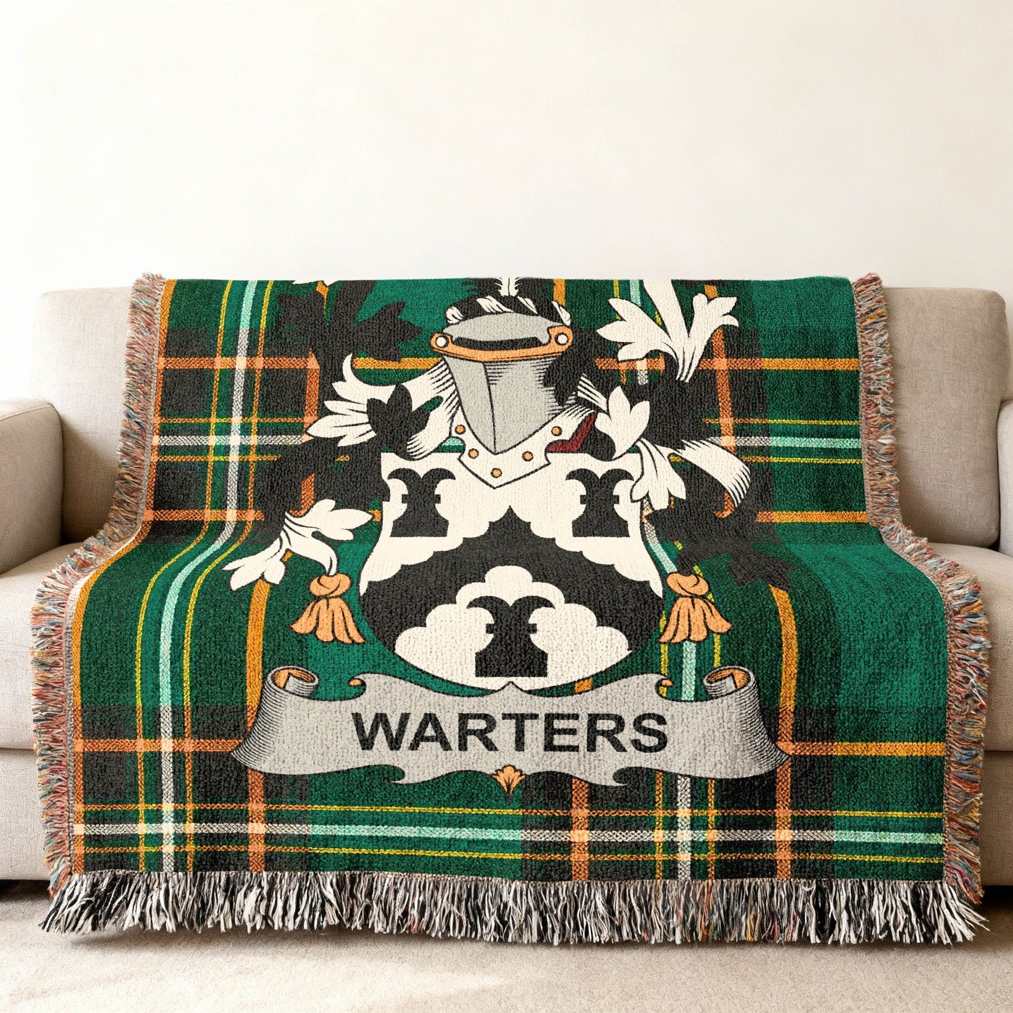 Warters family crest on a green and black tartan throw blanket on a sofa.