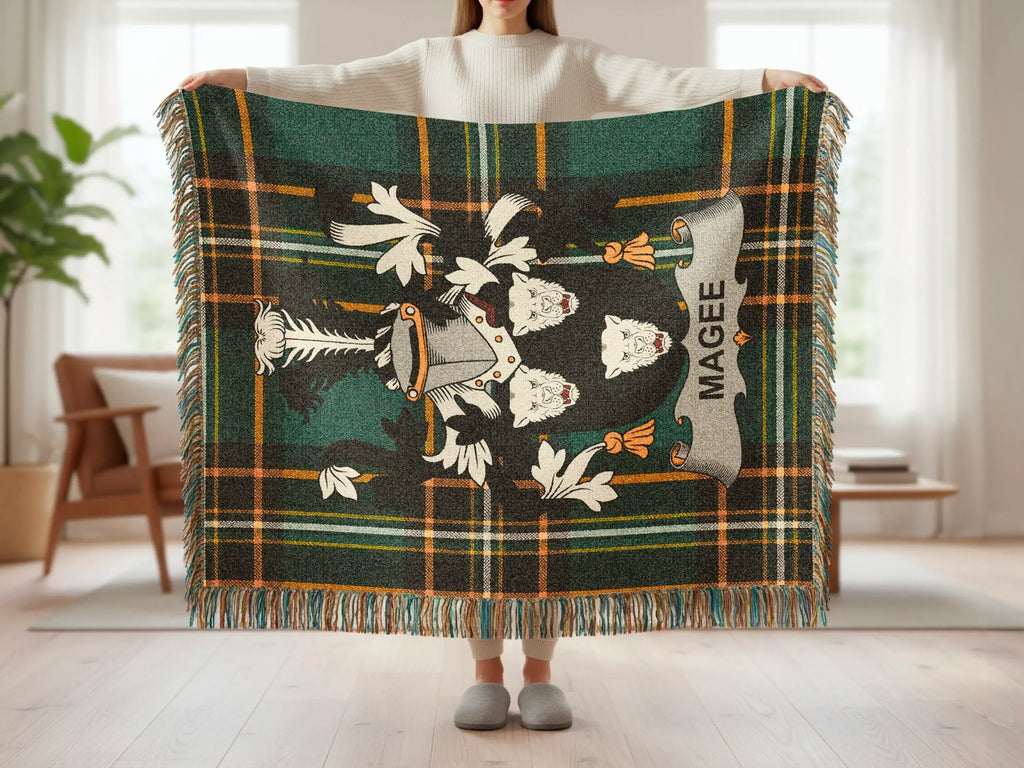 Magee tartan blanket with a central crest and fringed edges.
