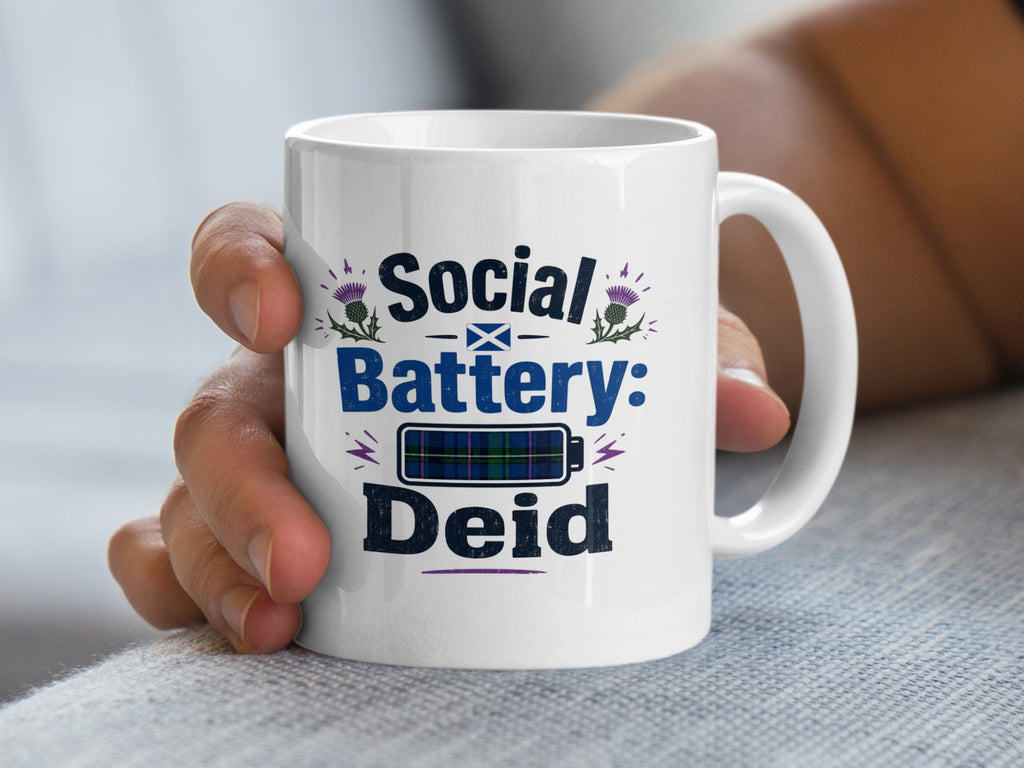 White mug with "Social Battery: Deid" text and tartan battery icon.