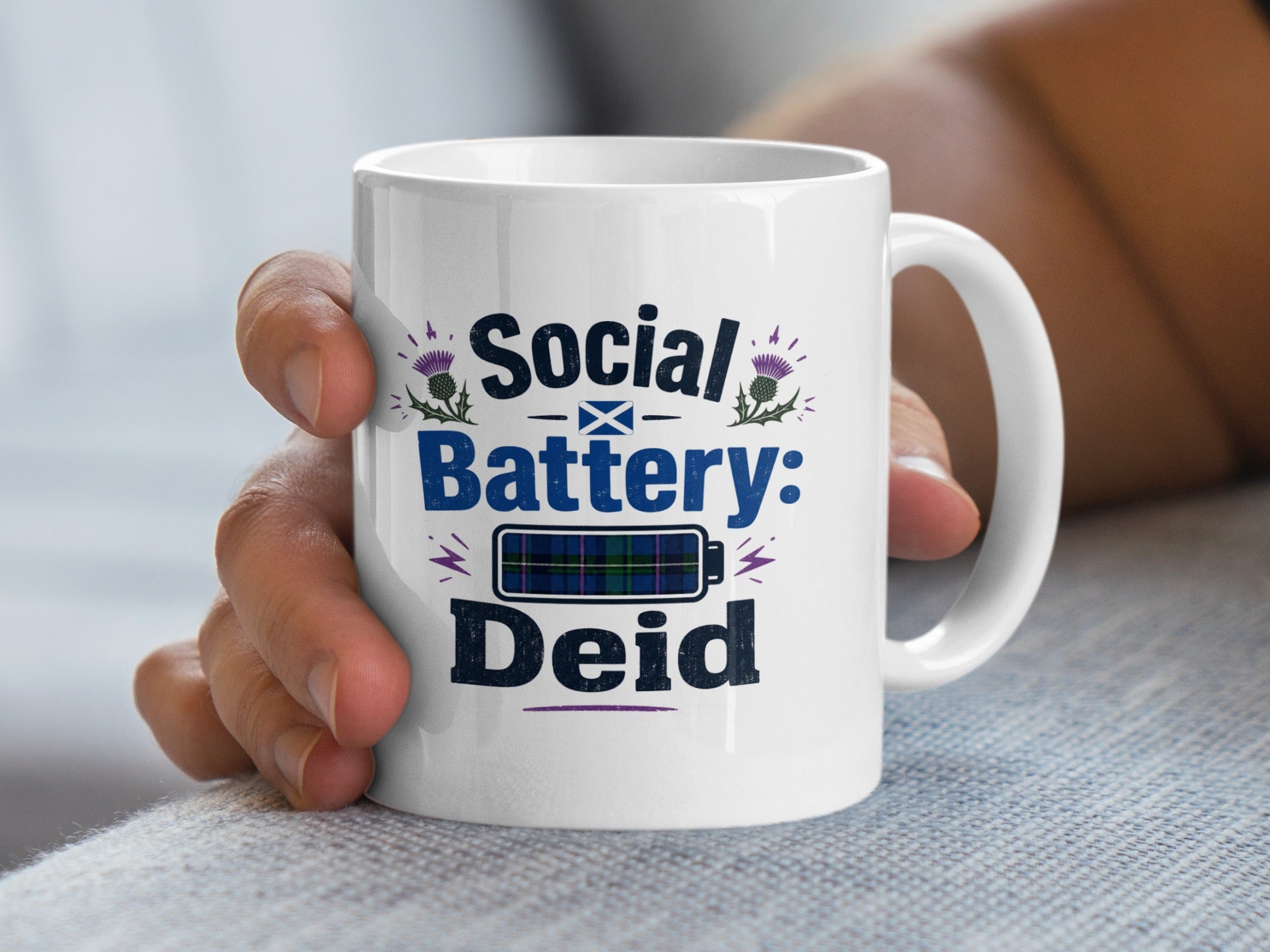 White mug with "Social Battery: Deid" text and tartan battery icon.