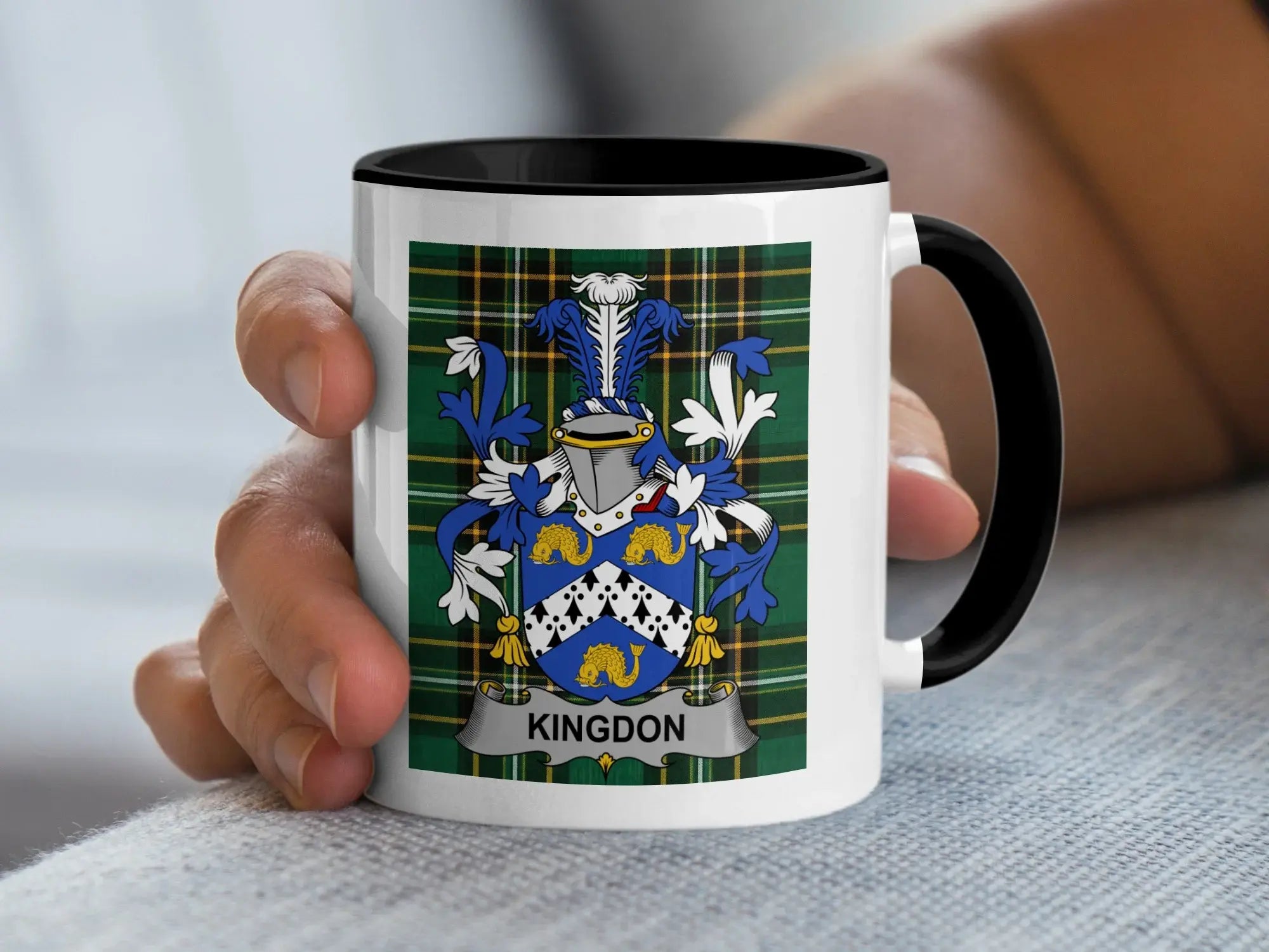 White mug with black rim featuring Kingdon family crest on plaid background.