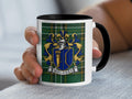 Moloney Irish family crest mug with black accents and Irish National Tartan, lifestyle view