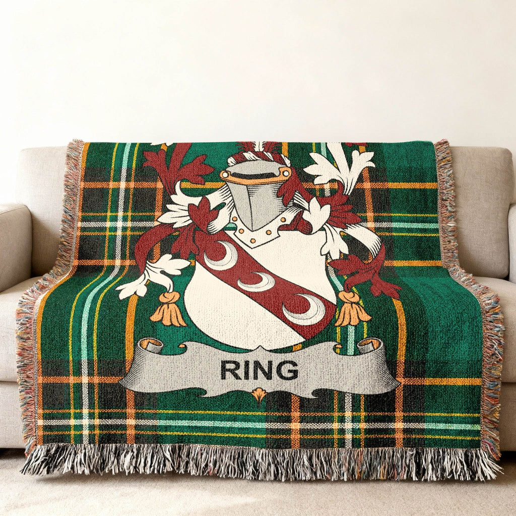 Green tartan throw blanket with a central shield featuring moons and the name RING.