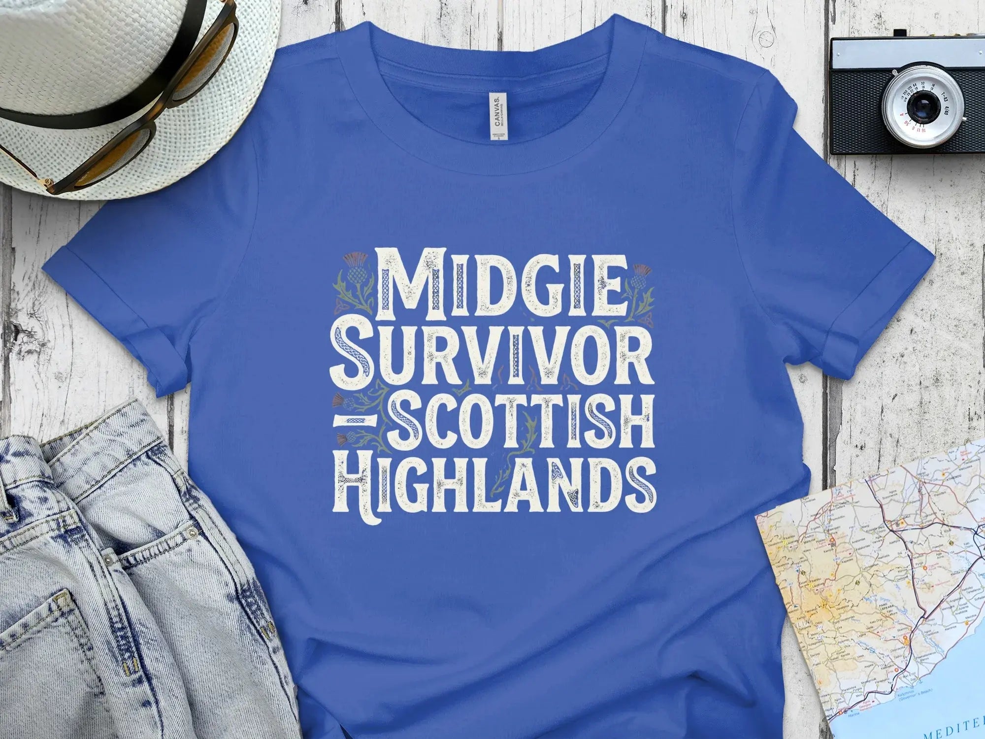 Blue t-shirt with "Midgie Survivor Scottish Highlands" text.