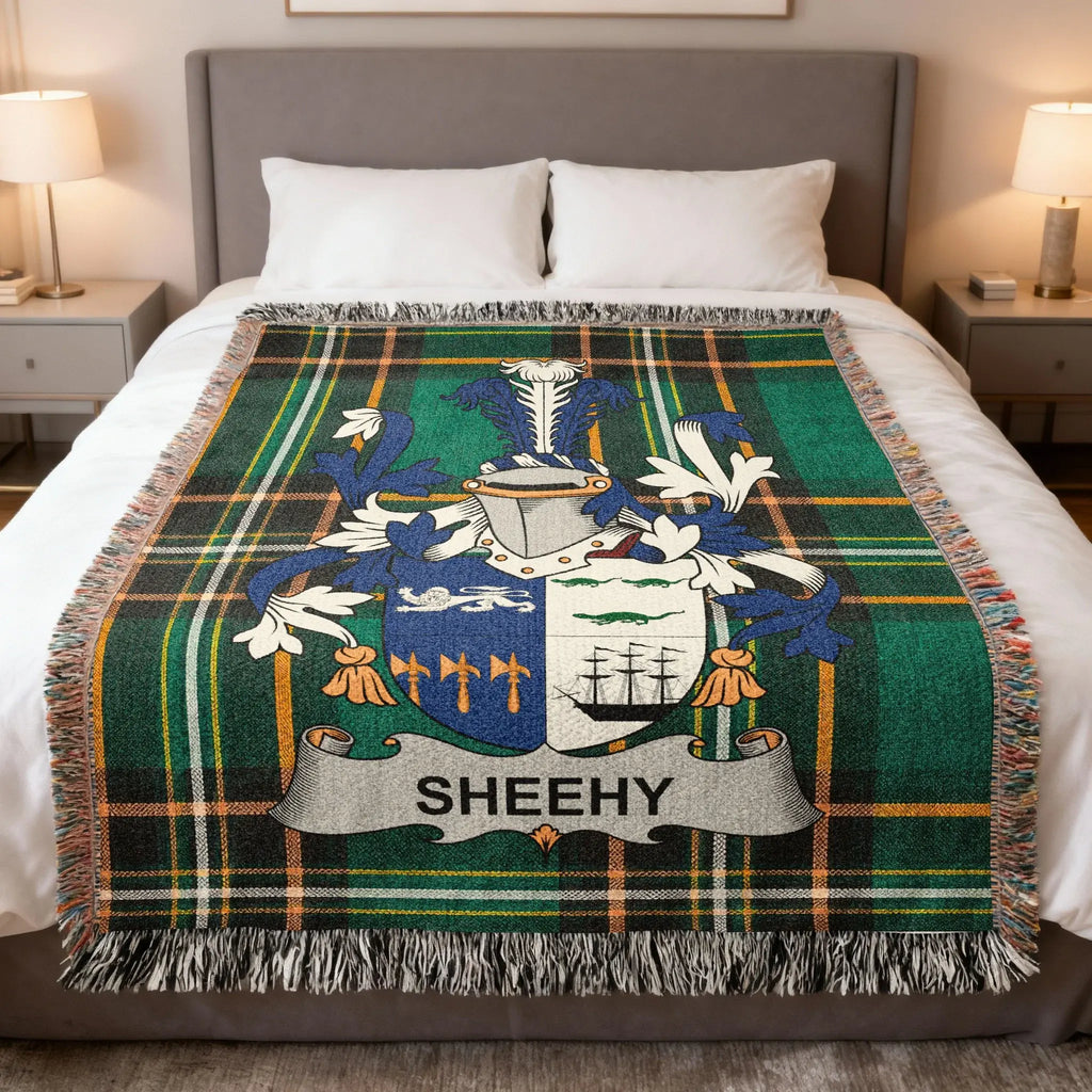 Tartan blanket with SHEEHY family crest on a bed.
