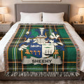 Tartan blanket with SHEEHY family crest on a bed.