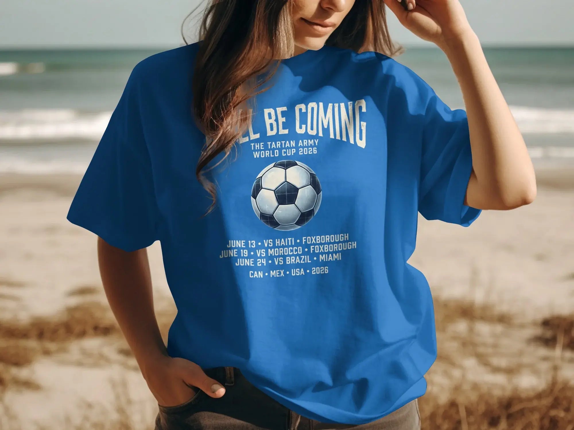 Blue t-shirt with "We'll Be Coming Home" and 2026 World Cup match details.