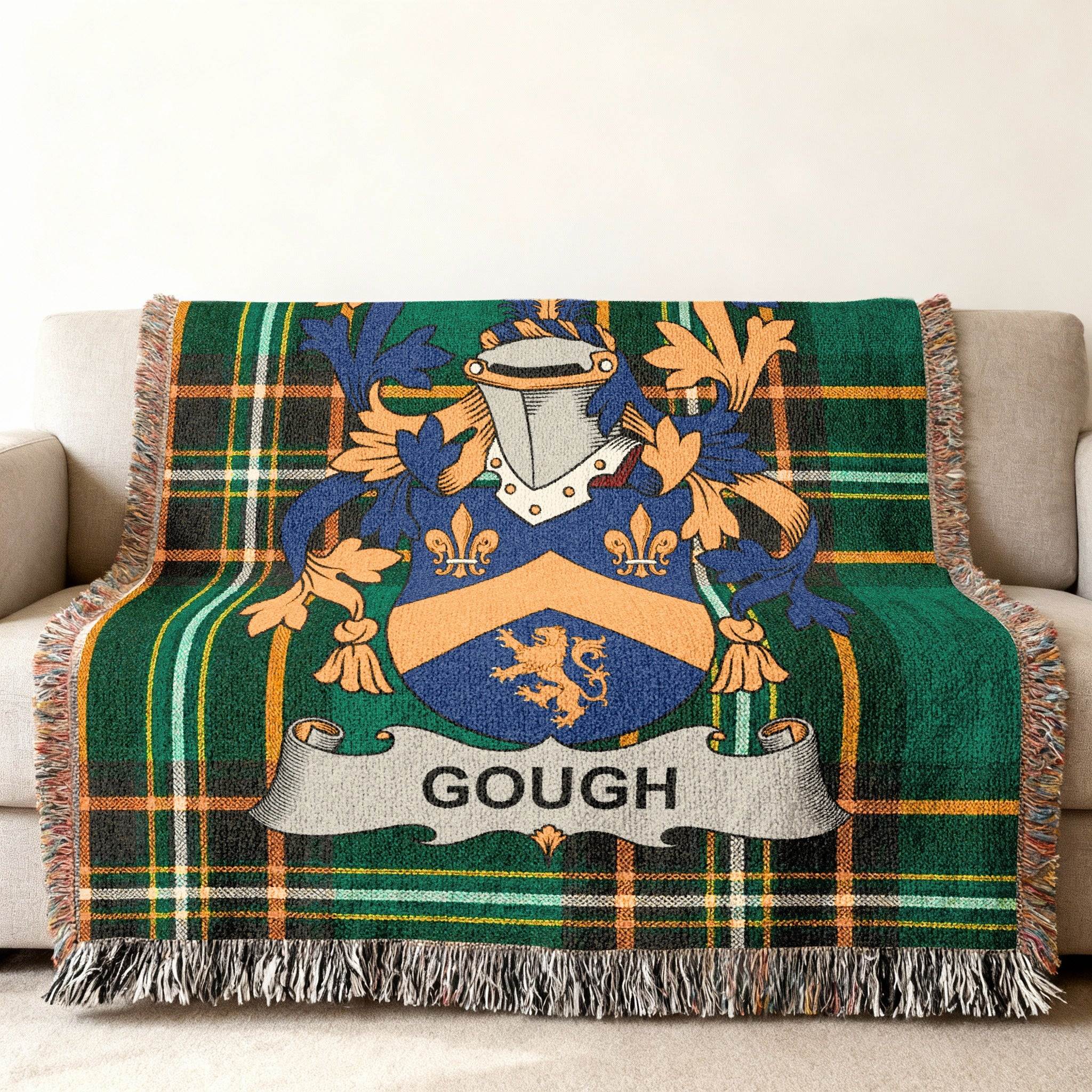 Woven throw blanket with a green plaid pattern and a family crest for "GOUGH".