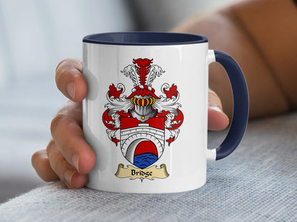White mug with blue handle and Bridge family crest.