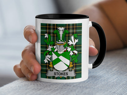 White mug with black rim featuring green plaid and Stokes family crest.