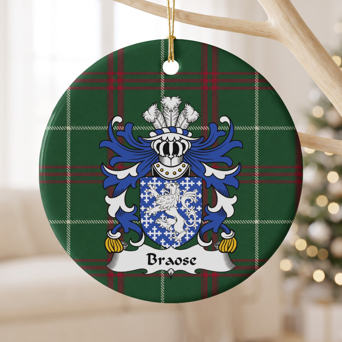 Braose ornament hanging from a pale wooden branch; a white lion and small white crosses on blue on Welsh national tartan.