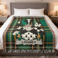 Green and black tartan blanket with a coat of arms and LOONEY name.