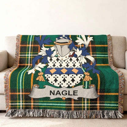 Nagle family crest on green tartan plaid blanket draped on a sofa.