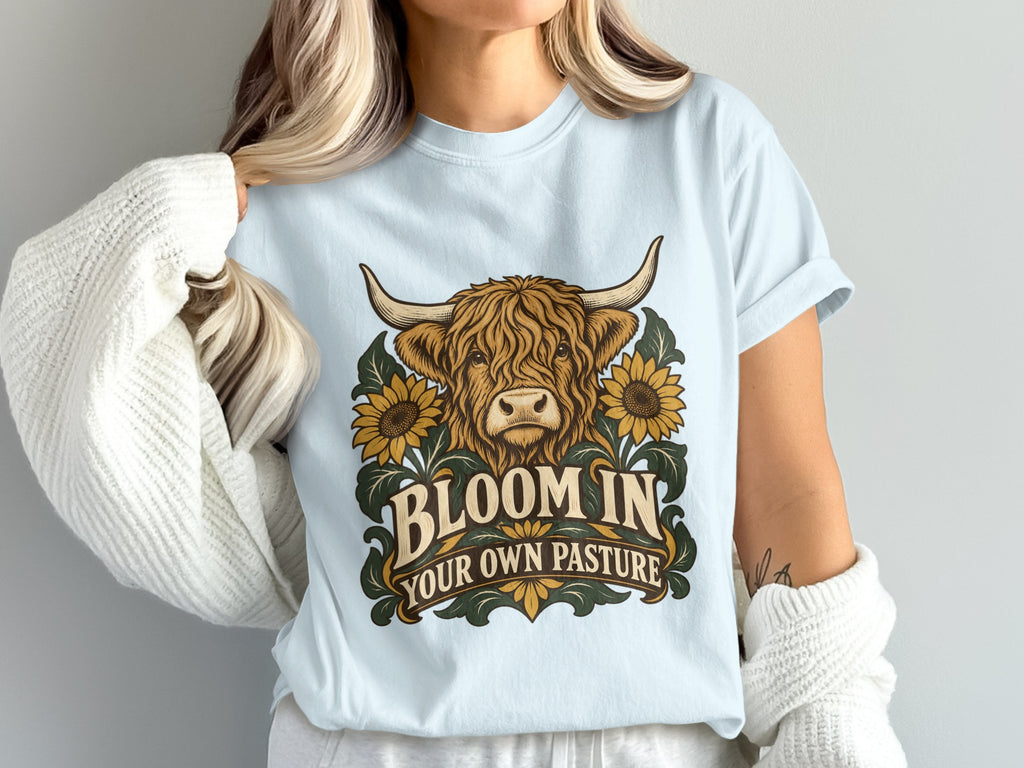 Model wearing the Bloom in Your Own Pasture Highland cow Comfort Colors T-shirt in Chambray