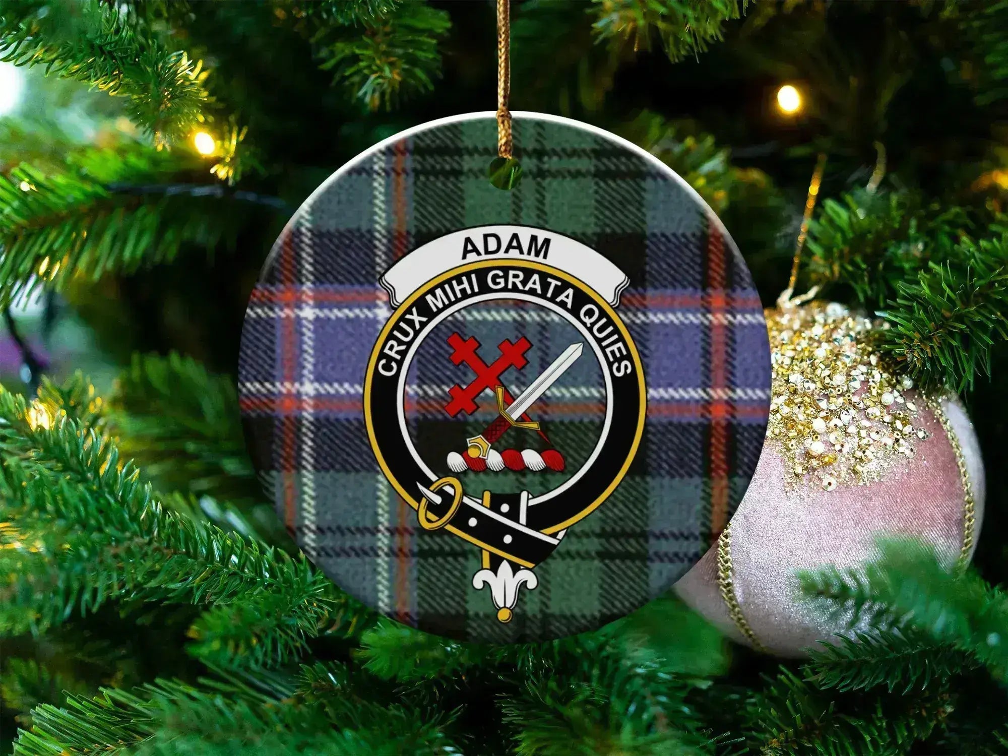 Adam ceramic ornament with crest and motto on a tartan-pattern background