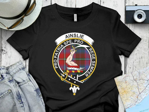 Ainslie crest T-shirt with tartan-pattern background, front view