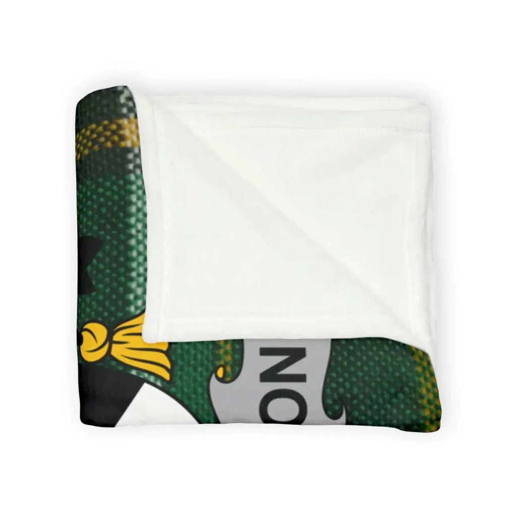 Anderson coat of arms printed blanket on sofa — Irish tartan design in green and gold