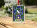 Close-up of the Brander family crest on a polished silver-frame metal ornament