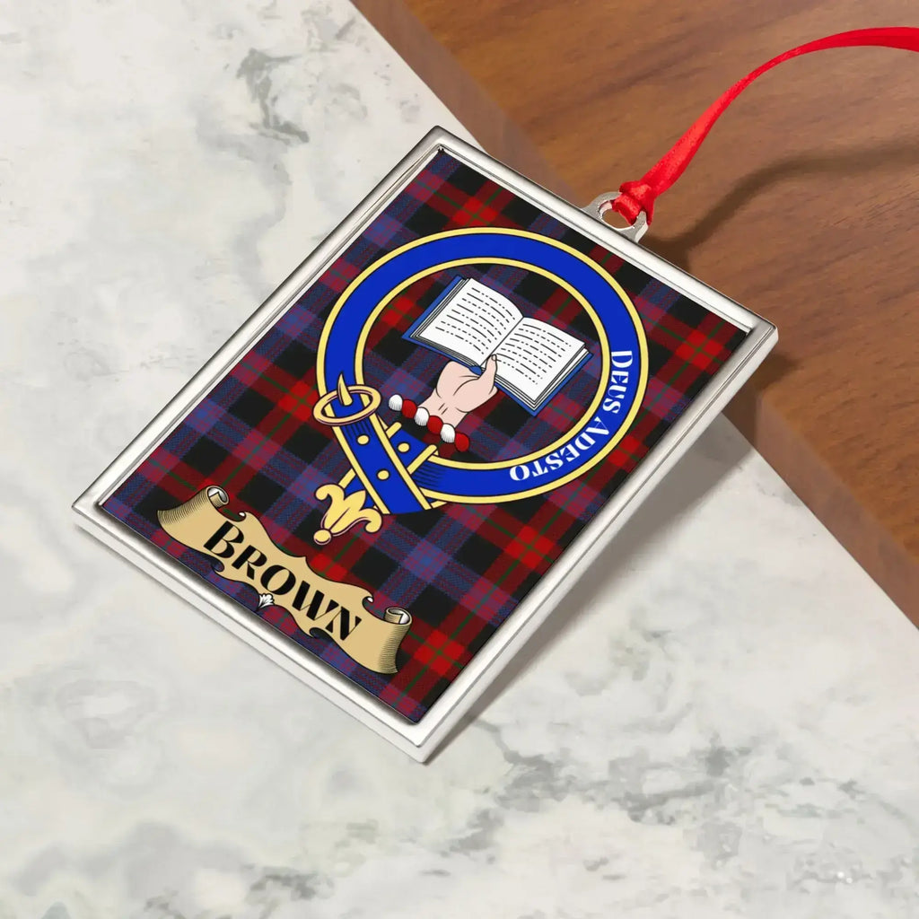 Brown ornament hanging from a Christmas tree branch by its satin ribbon