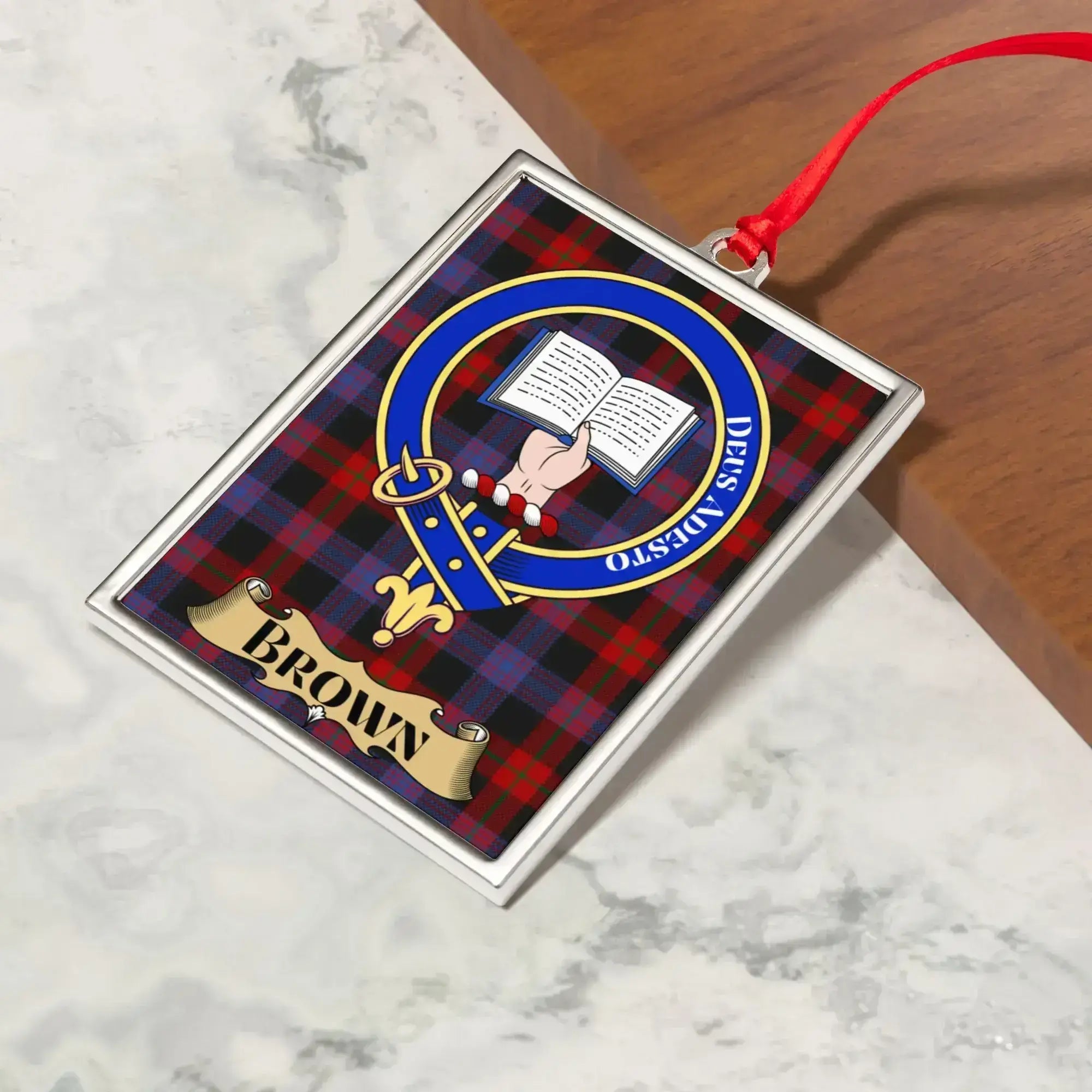 Brown ornament hanging from a Christmas tree branch by its satin ribbon