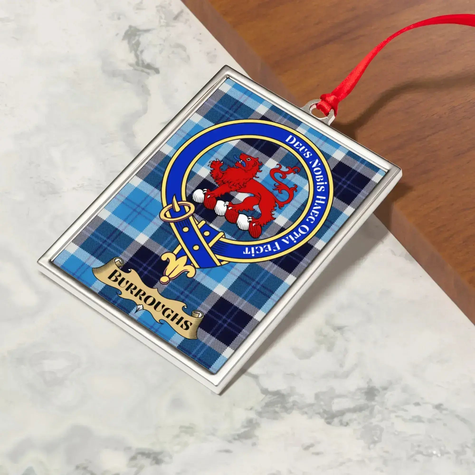 Burroughs ornament hanging from a Christmas tree branch by its satin ribbon