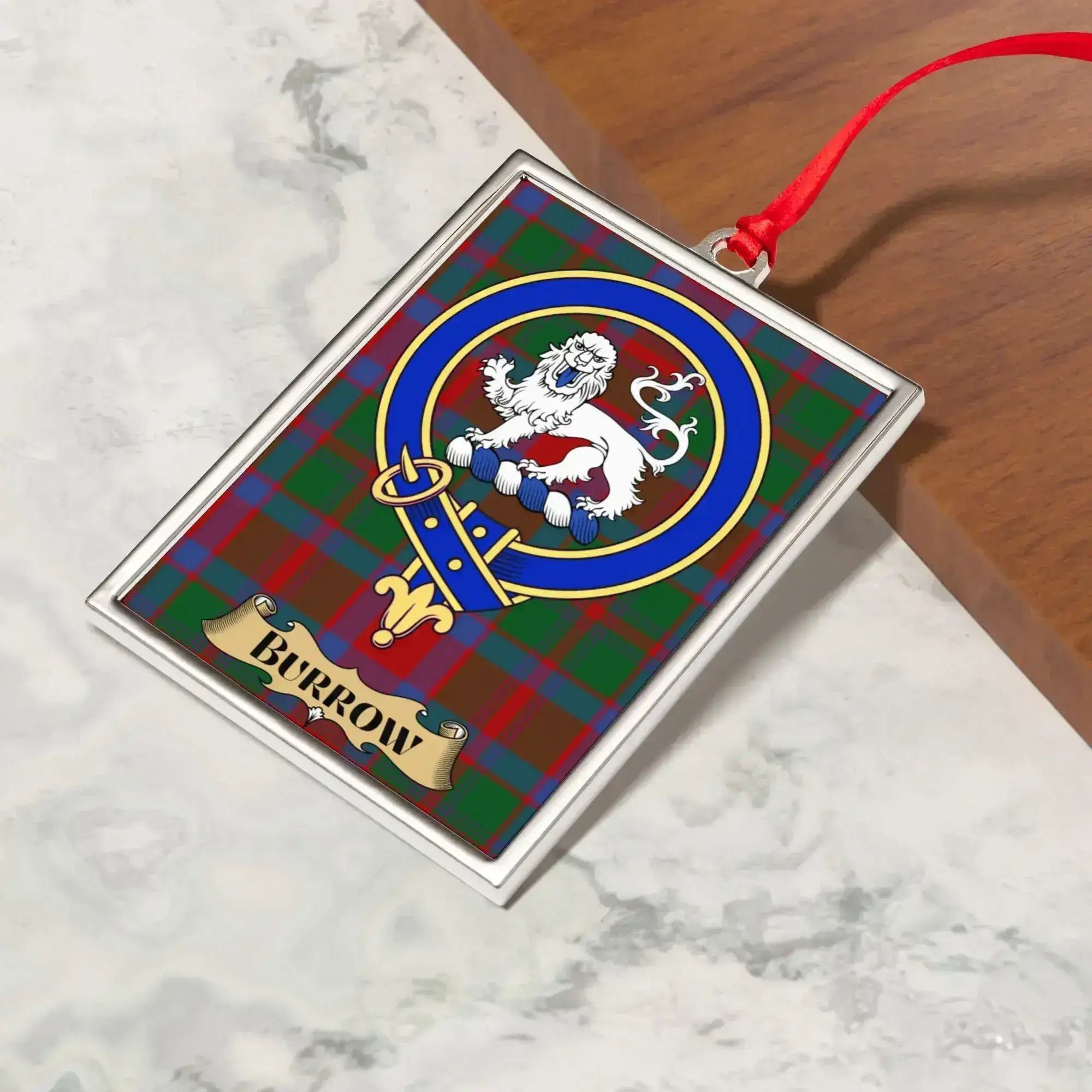 Burrow ornament hanging from a Christmas tree branch by its satin ribbon