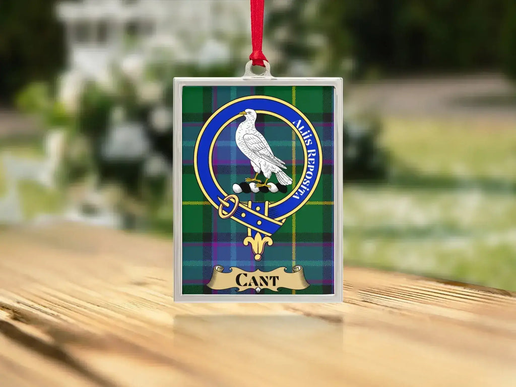 Close-up of the Cant family crest on a polished silver-frame metal ornament