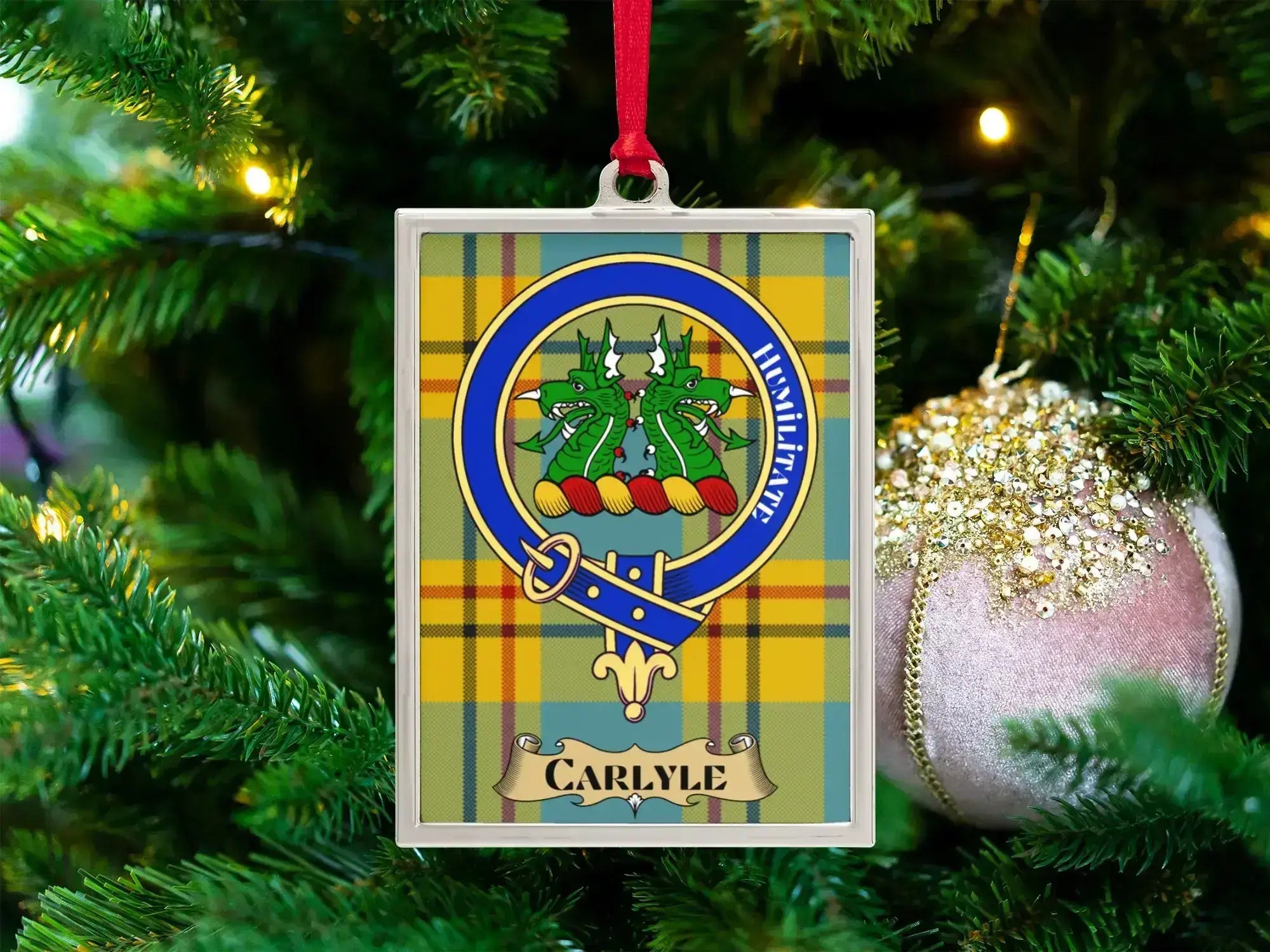 Carlyle clan crest Christmas ornament in a silver frame on a tartan background