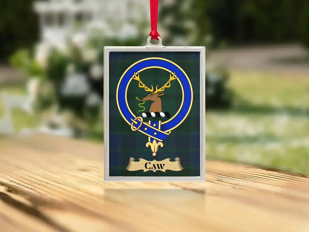 Close-up of the Caw family crest on a polished silver-frame metal ornament