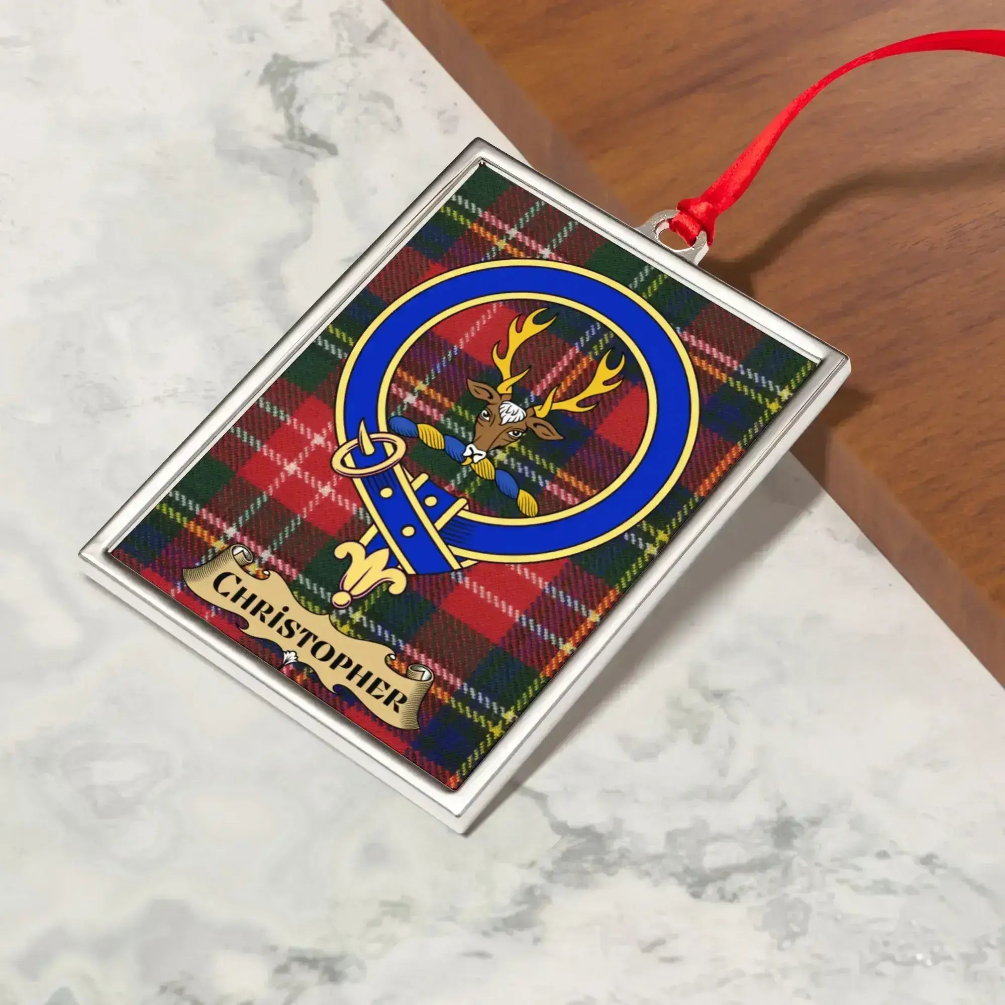 Christopher ornament hanging from a Christmas tree branch by its satin ribbon