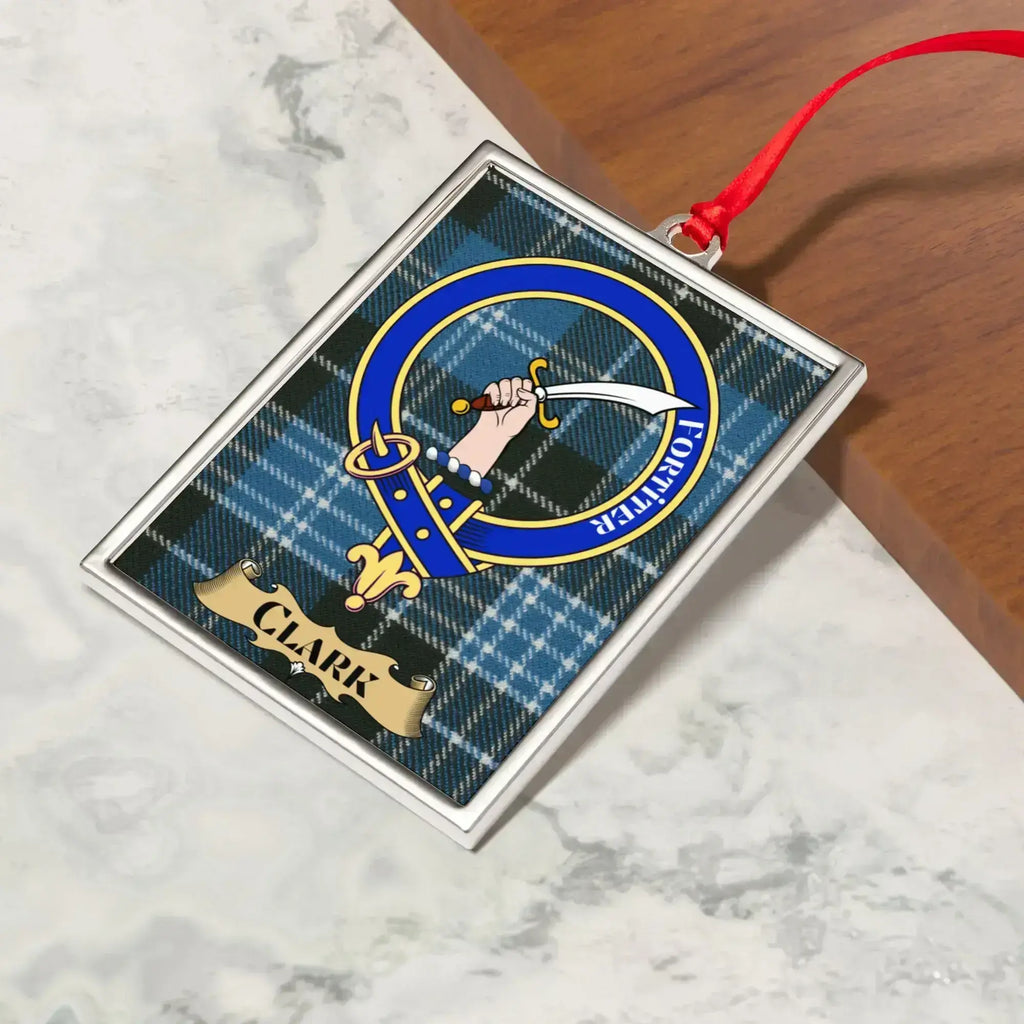 Clark ornament hanging from a Christmas tree branch by its satin ribbon