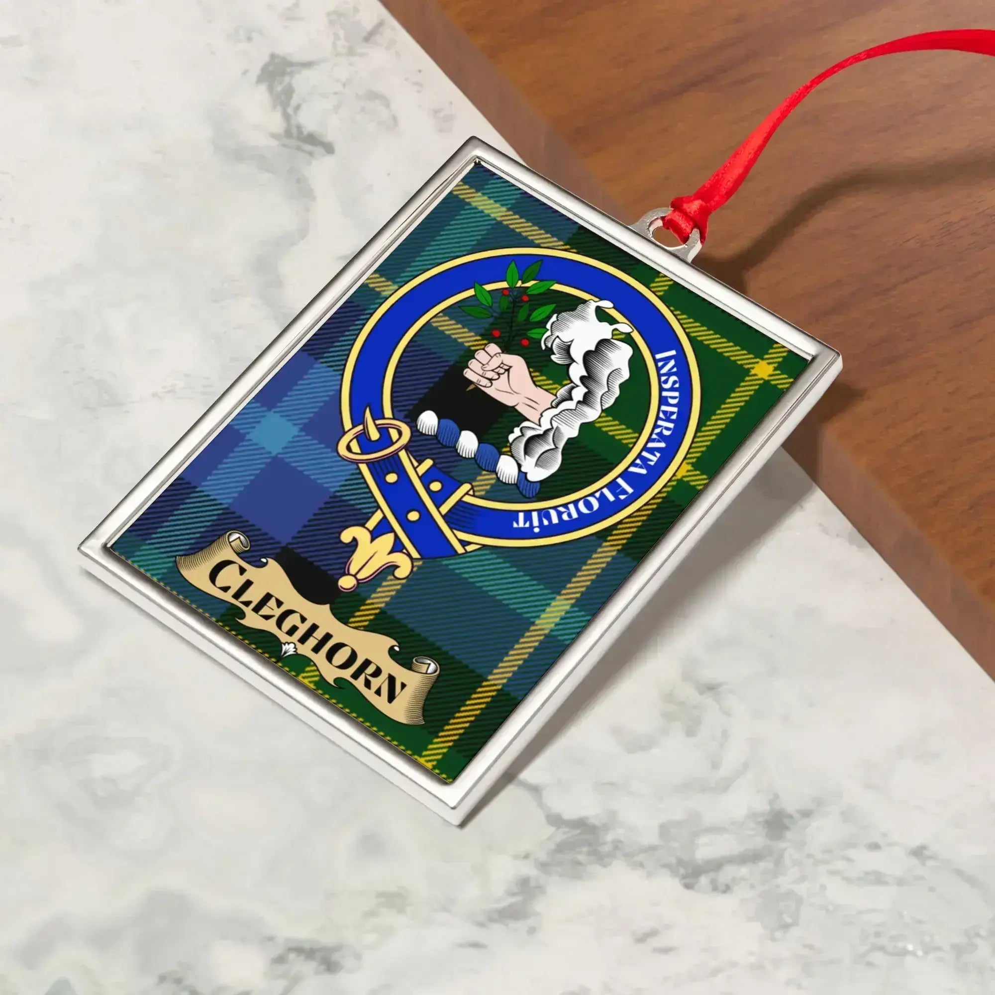 Cleghorn ornament hanging from a Christmas tree branch by its satin ribbon