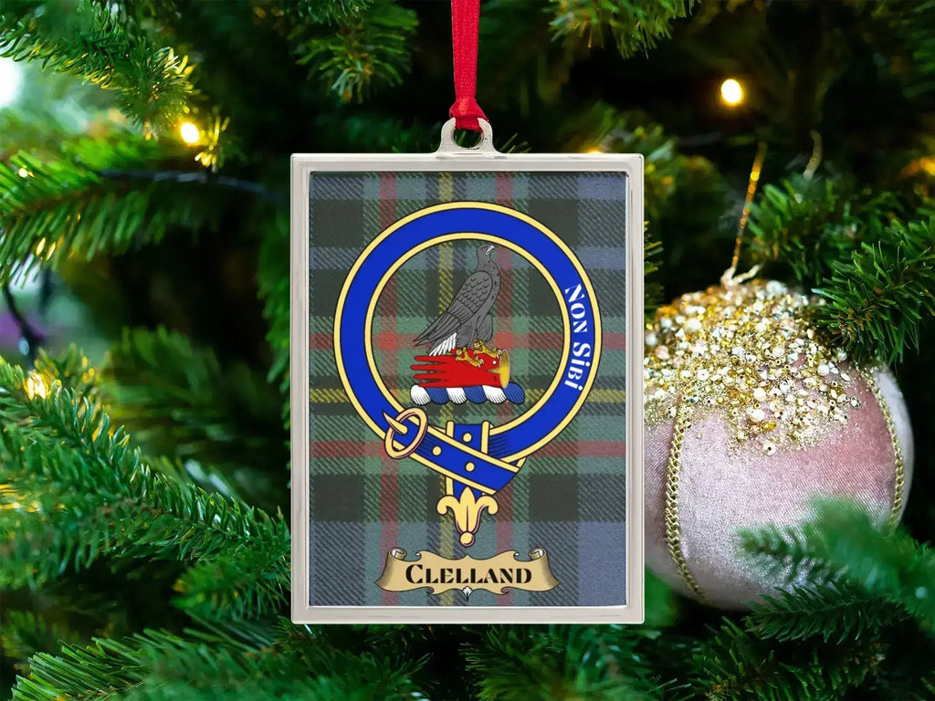 Clelland clan crest Christmas ornament in a silver frame on a tartan background