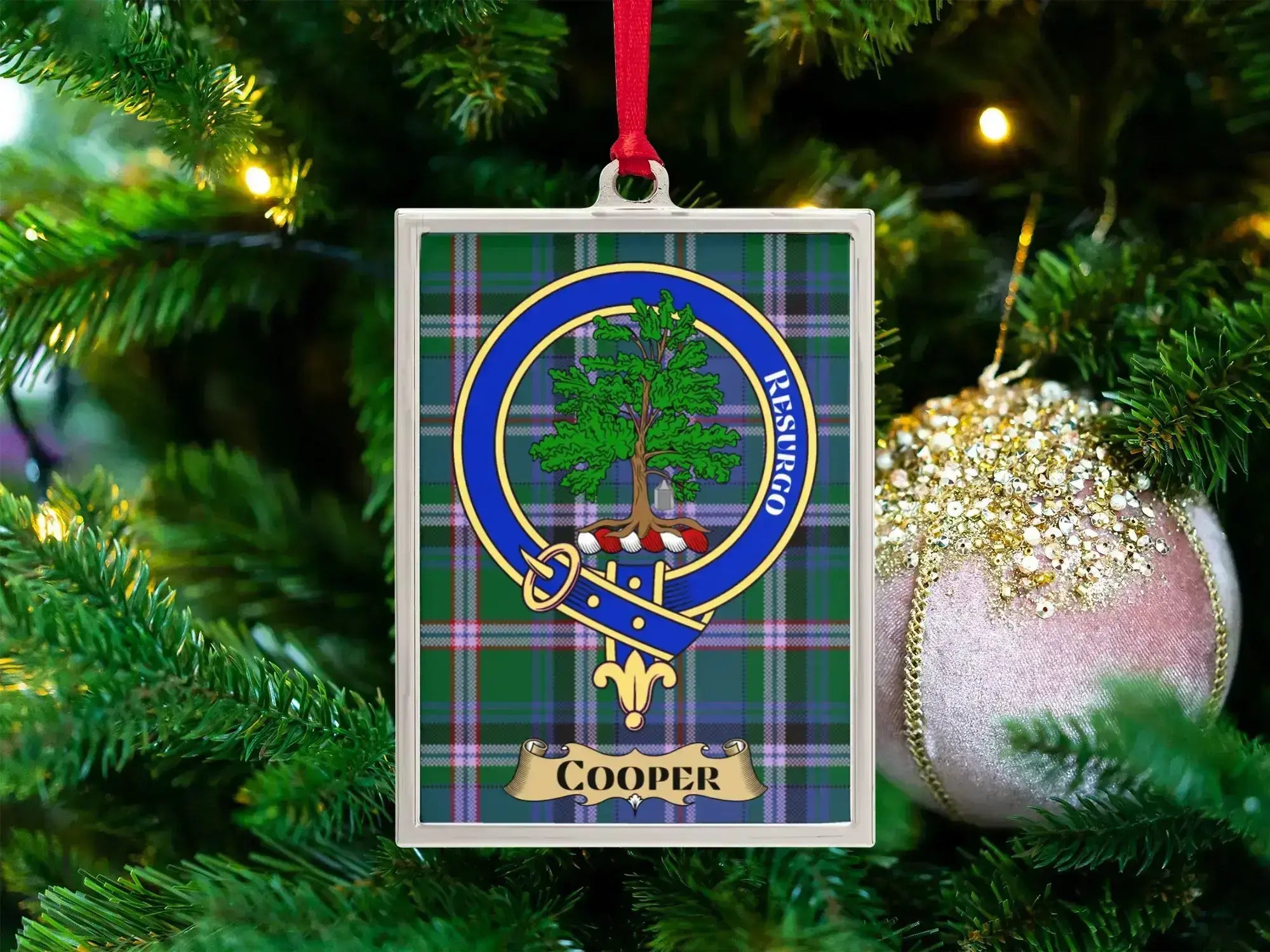 Cooper clan crest Christmas ornament in a silver frame on a tartan background